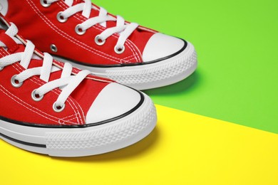 Pair of new stylish red sneakers on colorful background, closeup. Space for text