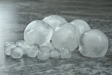 Photo of Many frozen ice balls on grey marble table