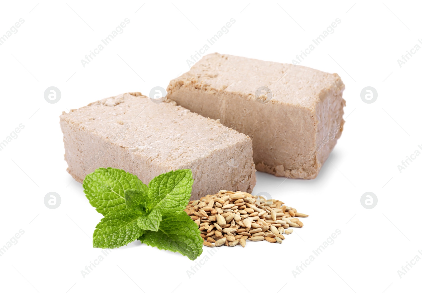 Image of Tasty halva, peeled sunflower seeds and mint leaves isolated on white