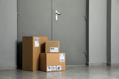 Photo of Cardboard boxes on floor near entrance. Parcel delivery service