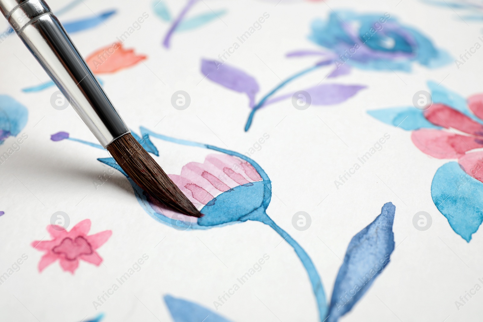 Photo of Painting flower with watercolor paint on white paper, closeup