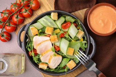 Photo of Delicious salad with croutons, chicken and vegetables served on grey table, flat lay