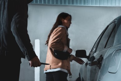 Photo of Man with knife stalking young woman on parking lot, closeup