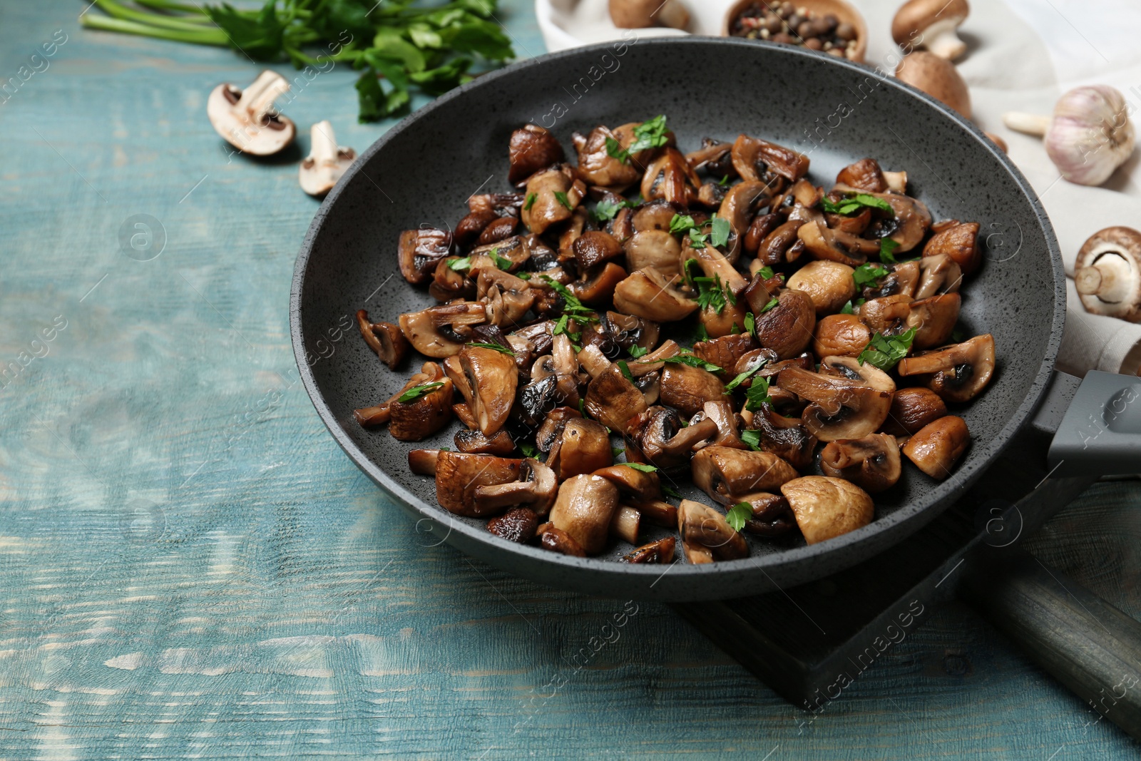 Photo of Frying pan with mushrooms on wooden table