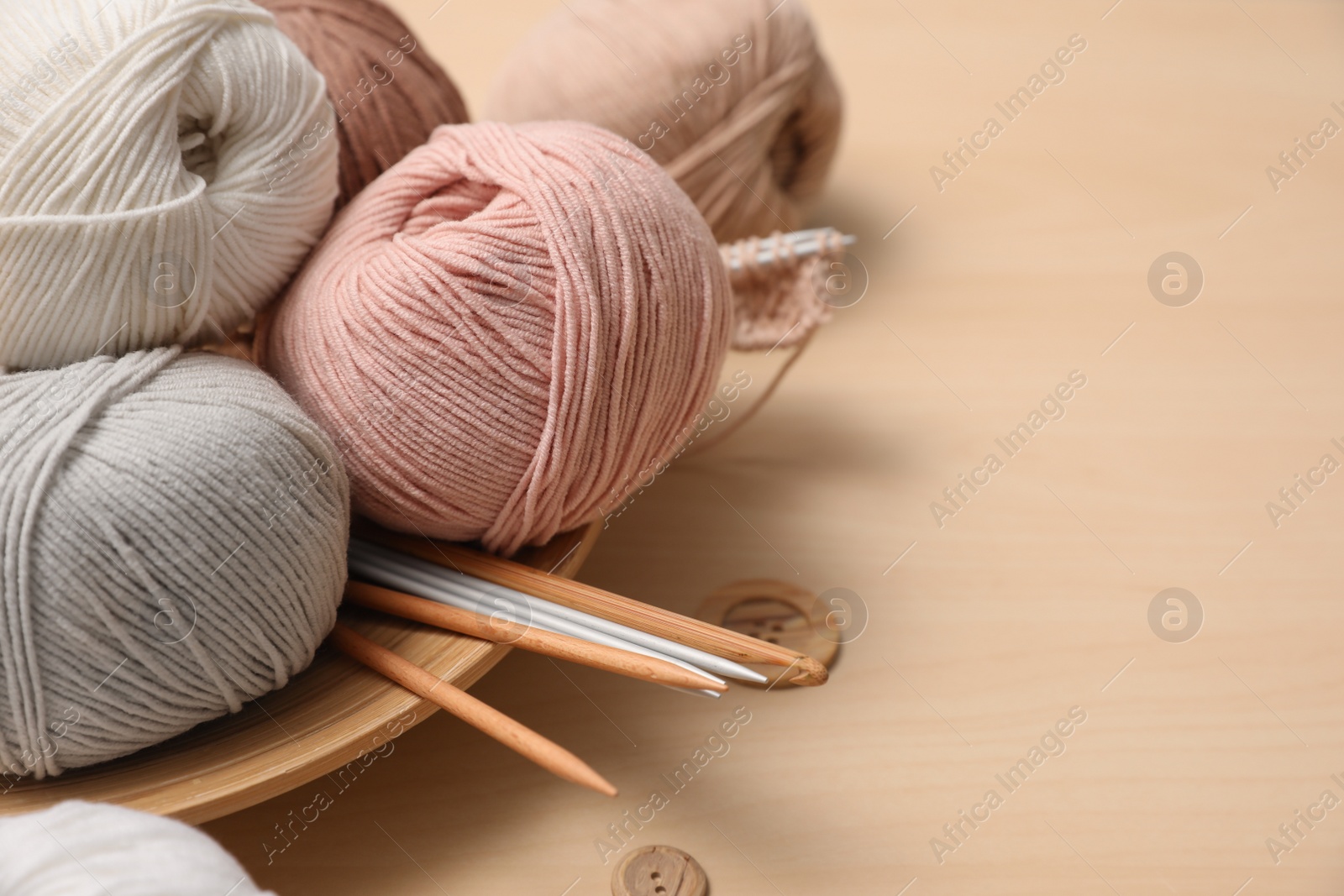 Photo of Composition with threads and crafting accessories on wooden table, space for text. Engaging hobby