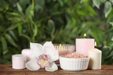 Beautiful spa composition with sea salt and candles on wooden table