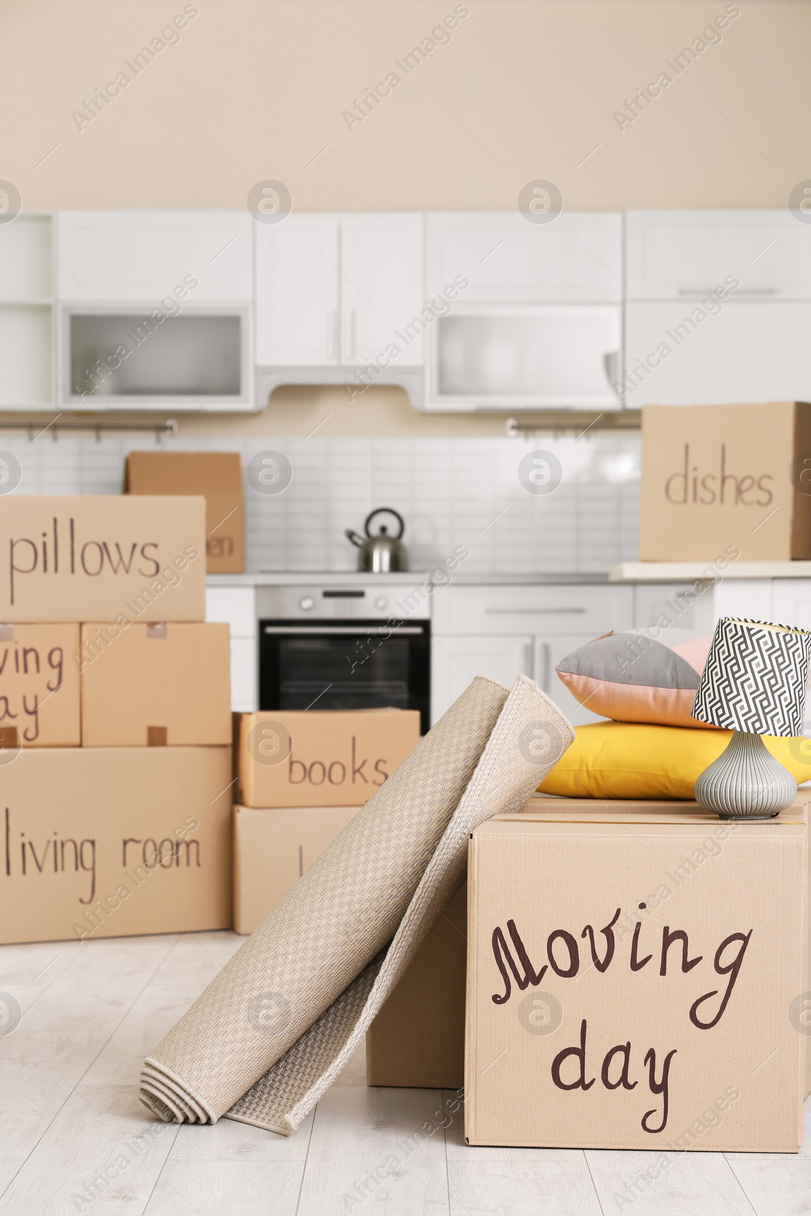 Photo of Cardboard boxes and household stuff in kitchen. Moving day