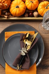 Photo of Thanksgiving table setting. Plates, cutlery, glass and autumn decor, flat lay