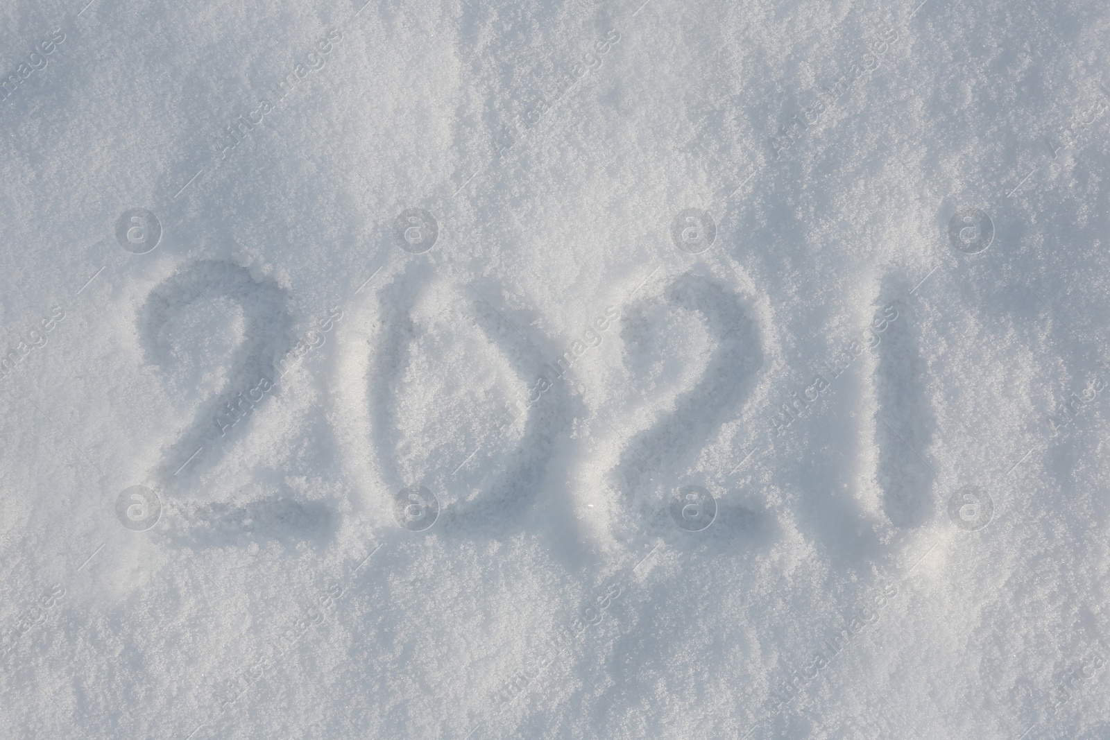 Photo of 2021 written on white snow, top view