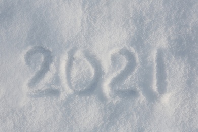 Photo of 2021 written on white snow, top view