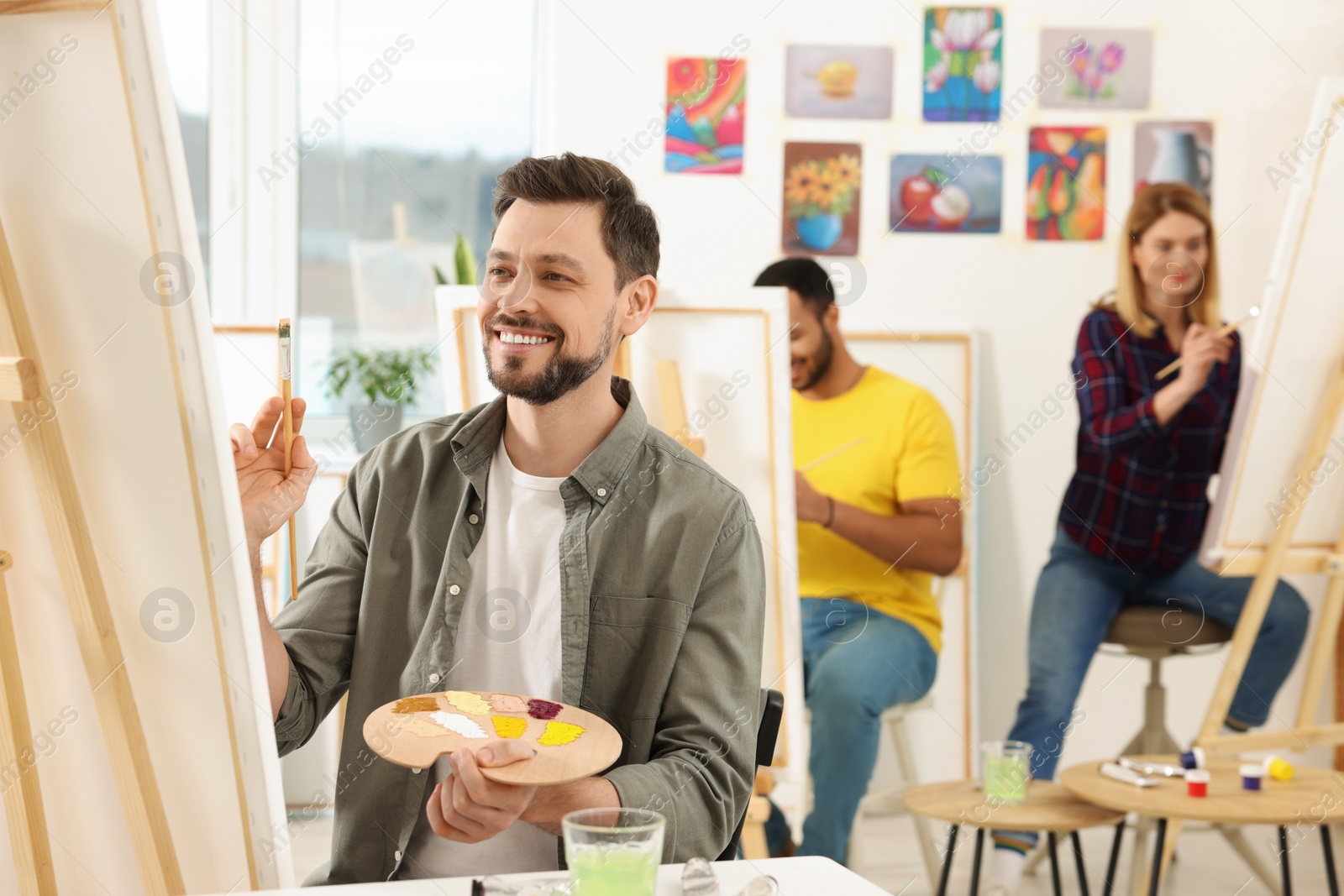 Photo of Group of students attending painting class in studio. Creative hobby