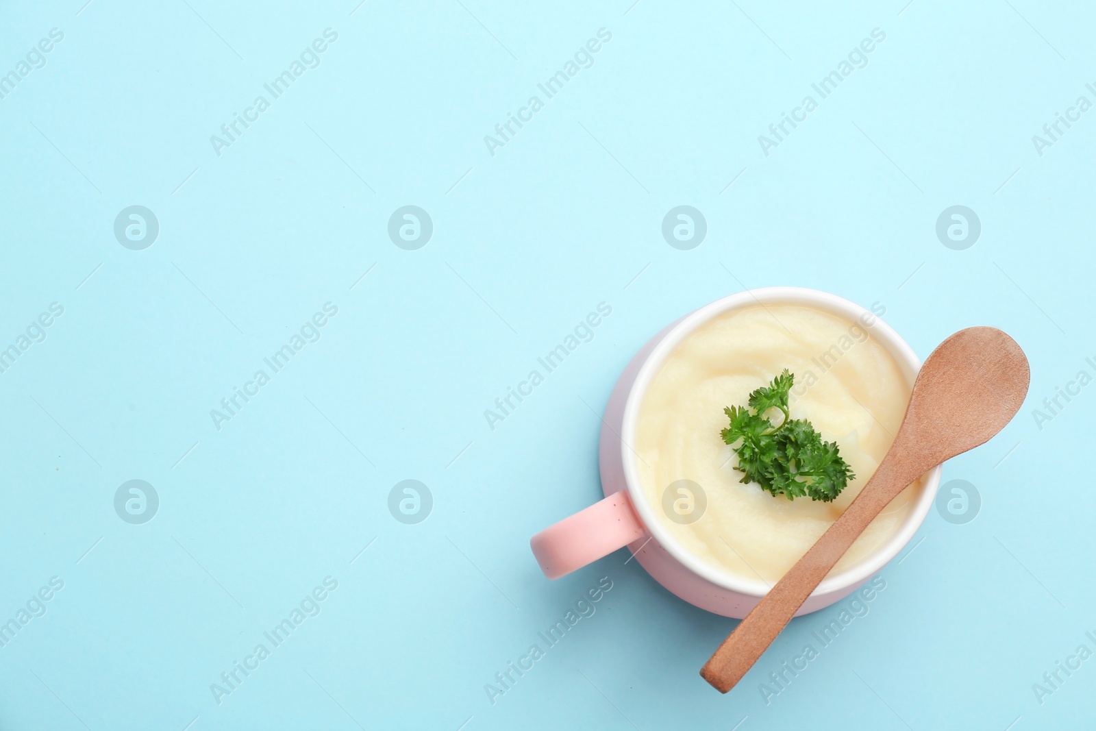 Photo of Bowl with tasty mashed potatoes and space for text on color background, top view