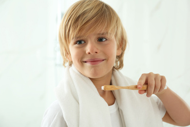 Cute little boy brushing teeth in bathroom