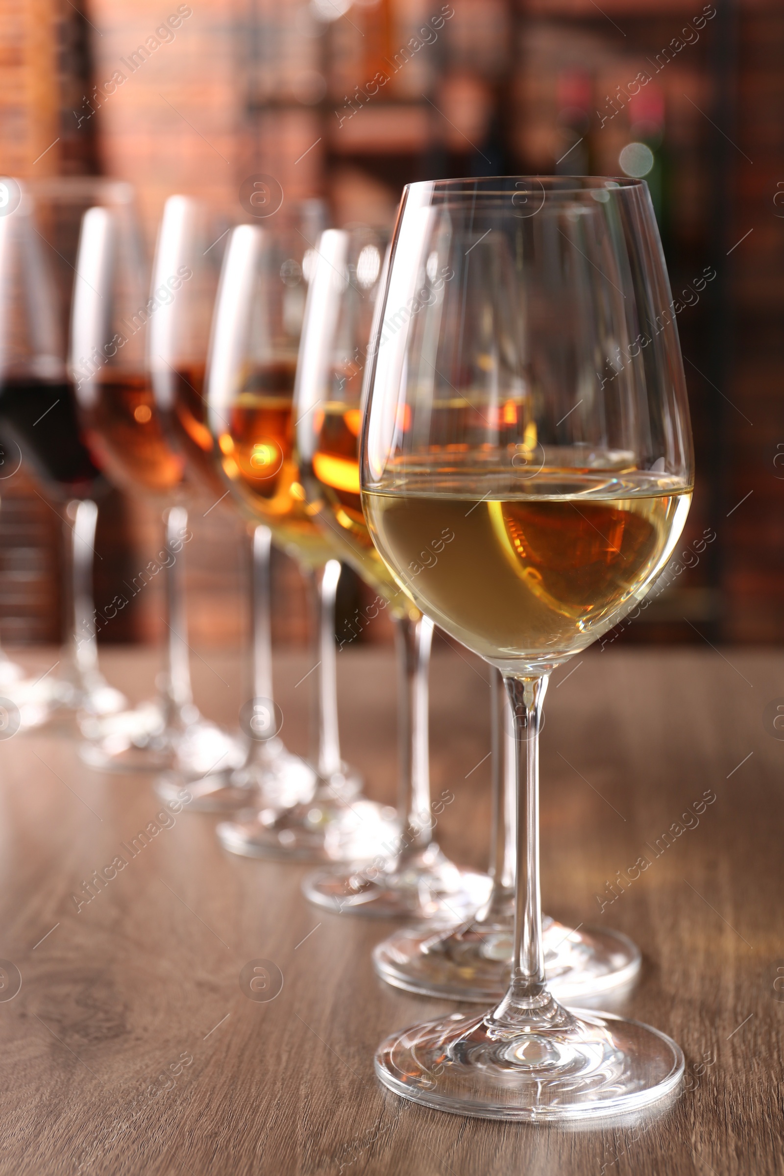 Photo of Different tasty wines in glasses on wooden table