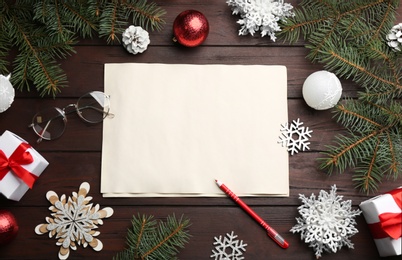 Photo of Flat lay composition with blank sheet of paper on wooden table, space for text. Writing letter to Santa