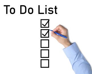 Image of To Do List. Man ticking check boxes with pen on white paper, top view