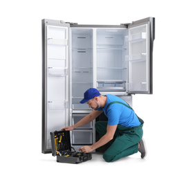 Photo of Male technician with tool box near refrigerator on white background