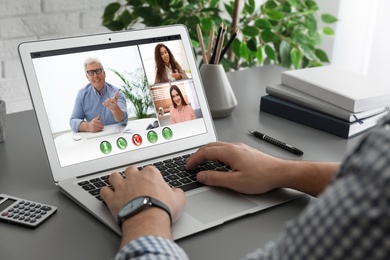 Image of Man having video chat with colleagues at table in office, closeup. Team work 