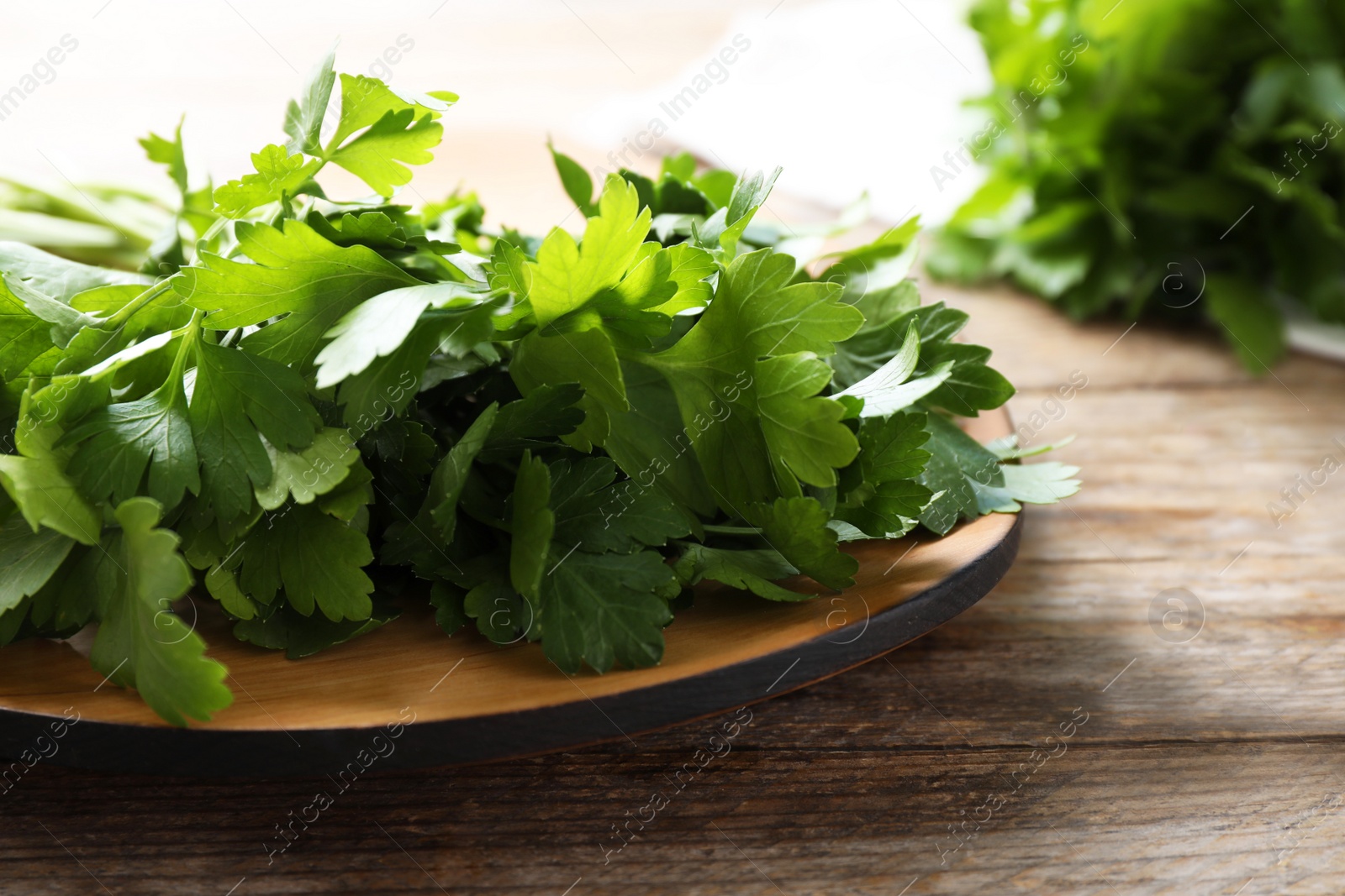 Photo of Bunch of fresh green parsley on wooden table, closeup