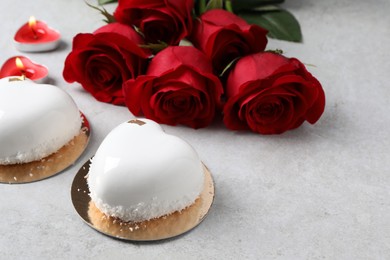 Photo of St. Valentine's Day. Delicious heart shaped cakes and roses on light table, closeup