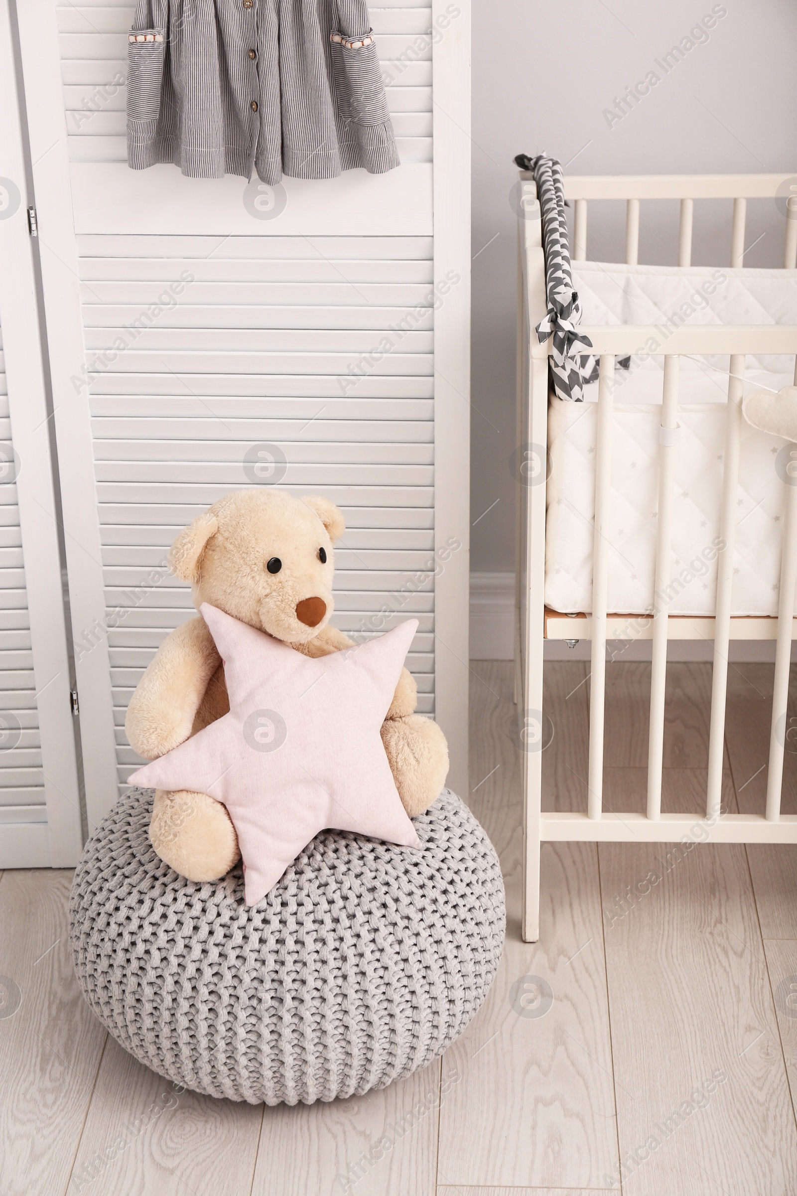 Photo of Stylish baby room interior with toys and comfortable crib