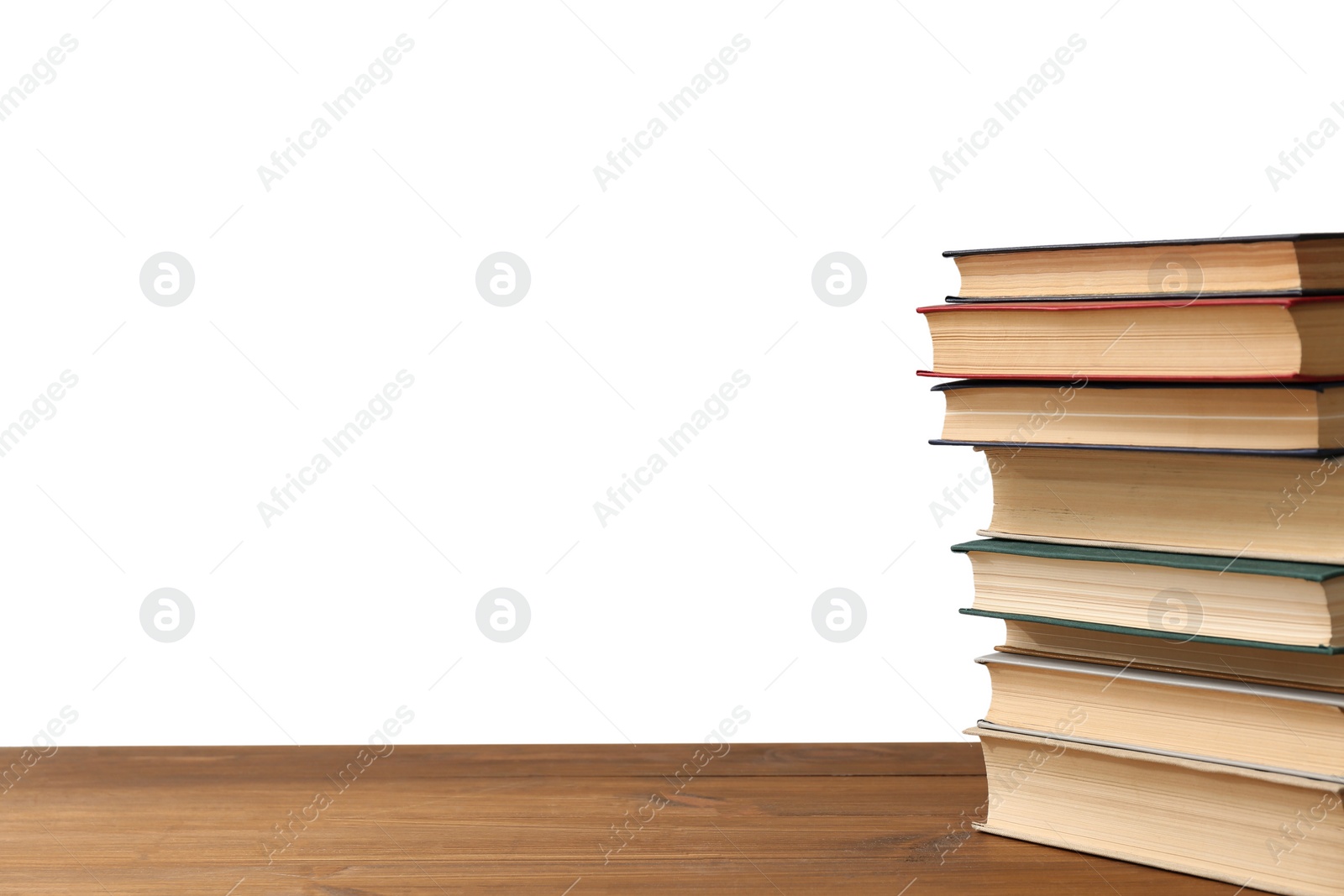 Photo of Stack of books on wooden table against white background. Library material