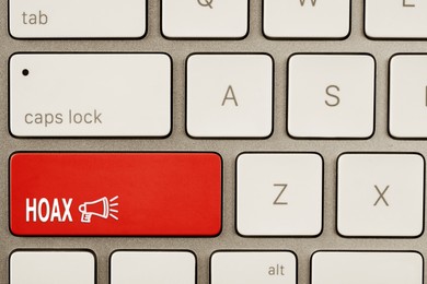 Image of Red button with word Hoax and loudspeaker on computer keyboard, top view