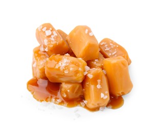 Photo of Yummy caramel candies and sea salt isolated on white