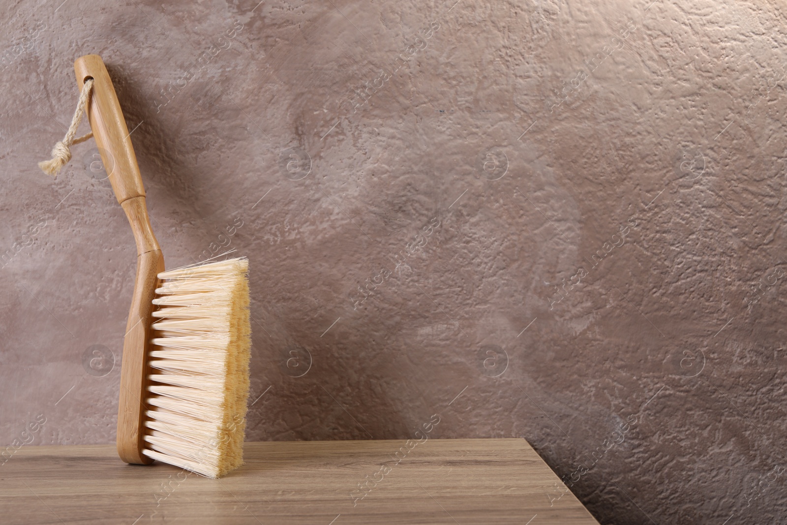 Photo of One cleaning brush on wooden table. Space for text