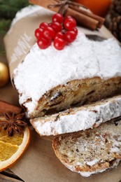 Traditional Christmas Stollen with icing sugar and cranberries on wooden table, closeup