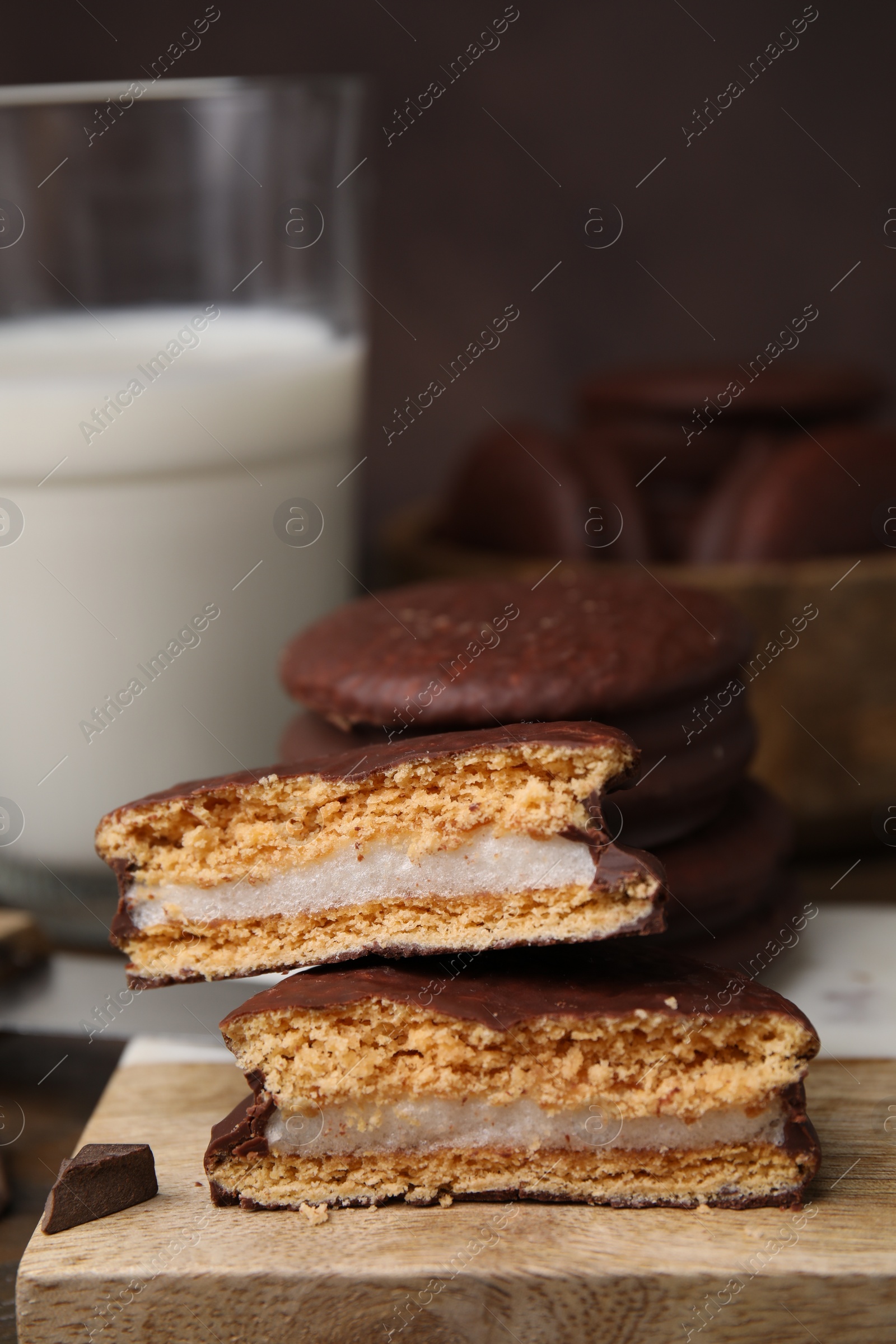 Photo of Tasty choco pies on wooden board, closeup. Space for text