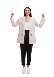 Beautiful businesswoman in suit pointing at something on white background