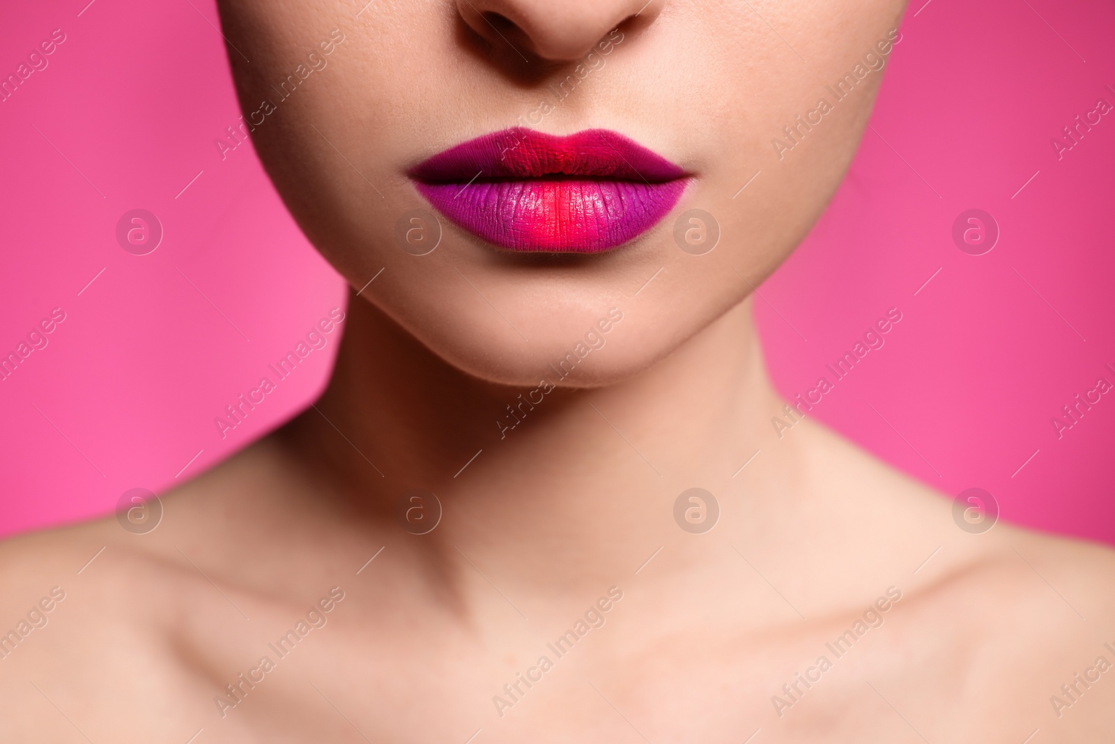 Photo of Young woman with beautiful lips makeup on pink background, closeup