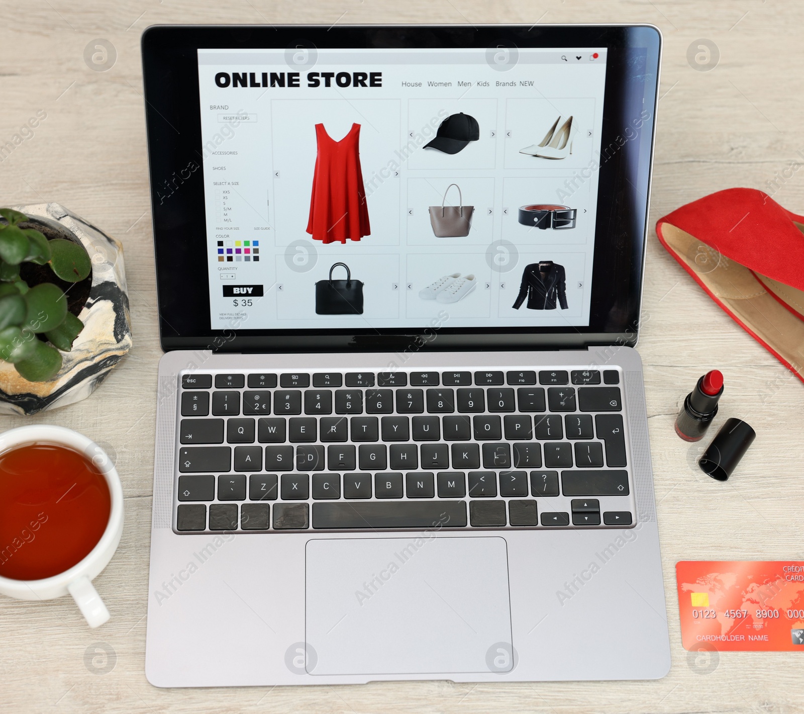 Photo of Laptop, credit card and cup of tea on wooden table, above view. Online store