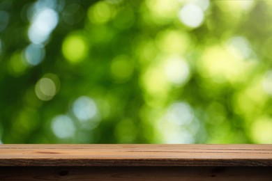 Image of Empty wooden surface against blurred green background. Space for design