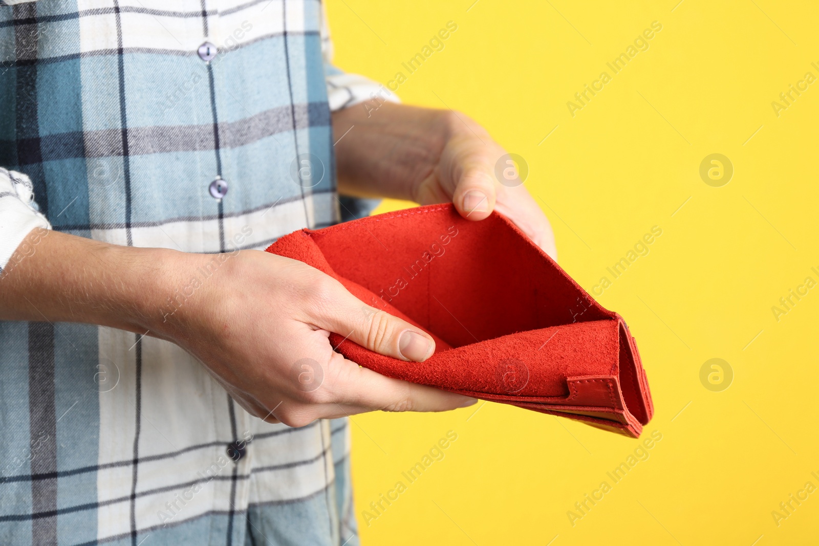Woman showing empty wallet on yellow background, closeup Photo of Woman showing empty wallet on yellow background, closeup
