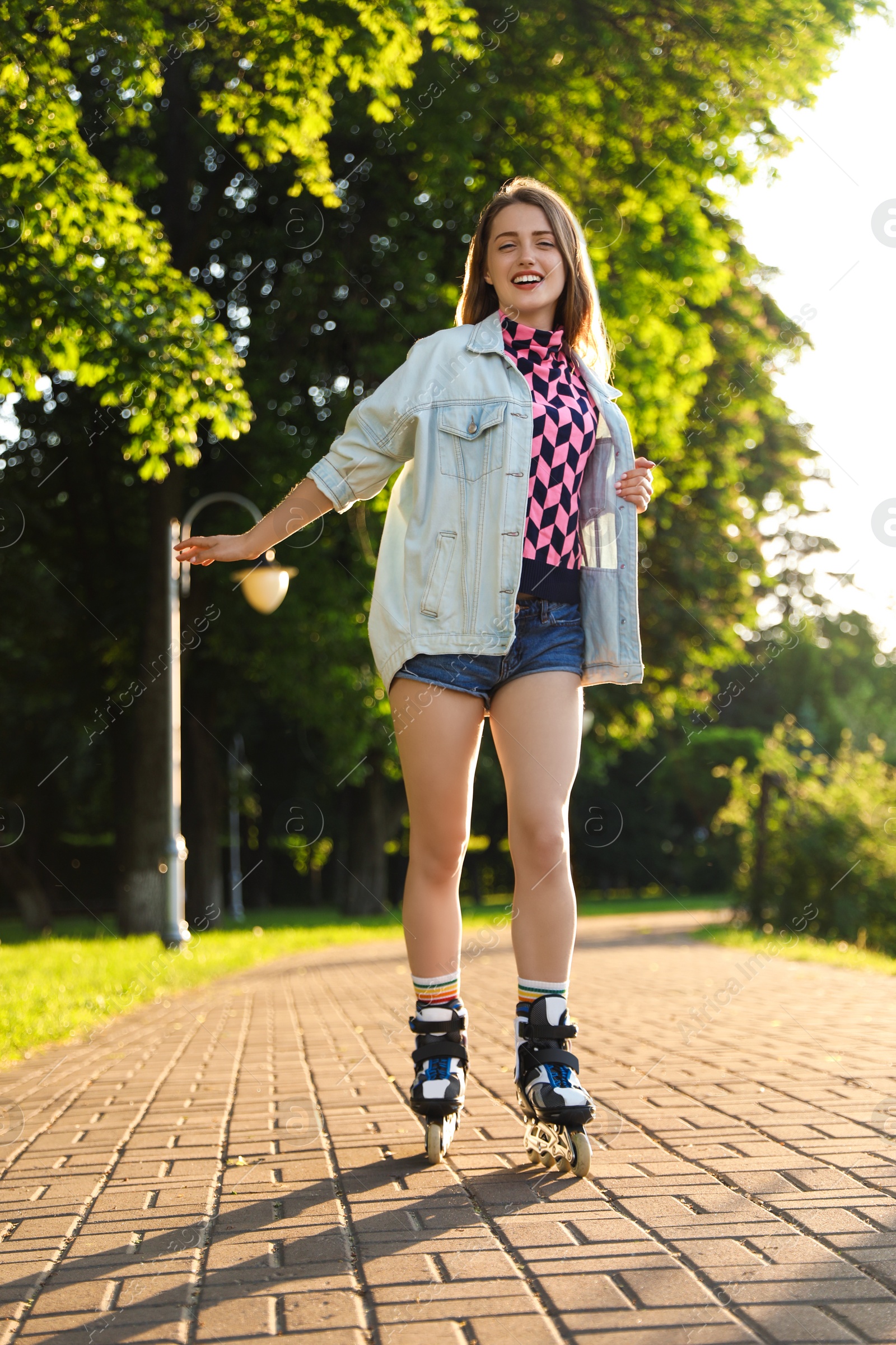 Photo of Beautiful young woman with roller skates having fun outdoors