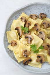 Photo of Delicious ravioli with mushrooms on white table, top view