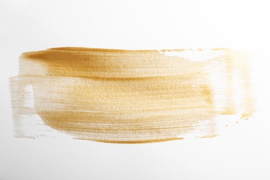 Photo of Strokes of gold paint isolated on white, top view