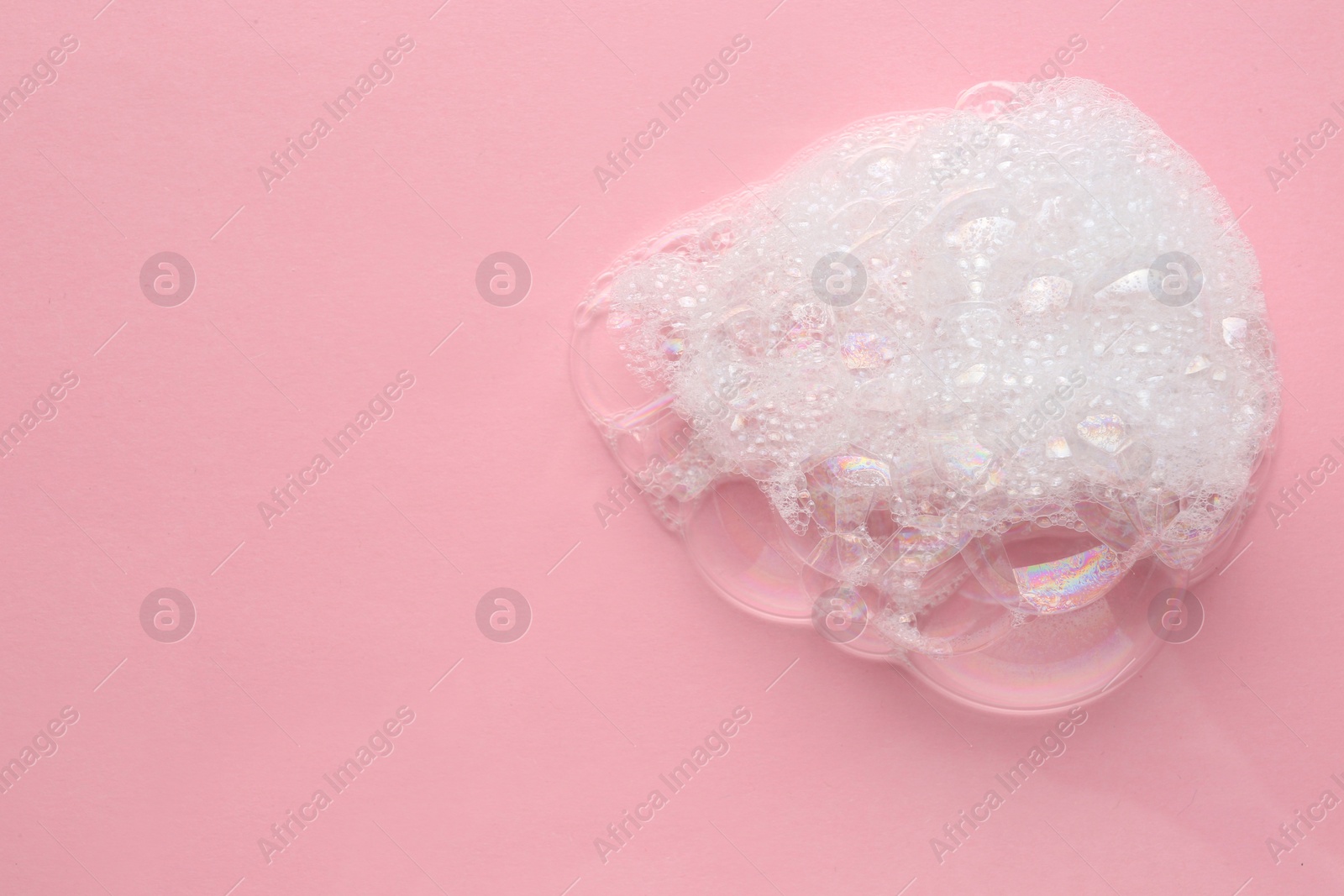 Photo of Drop of bath foam on pink background, top view. Space for text