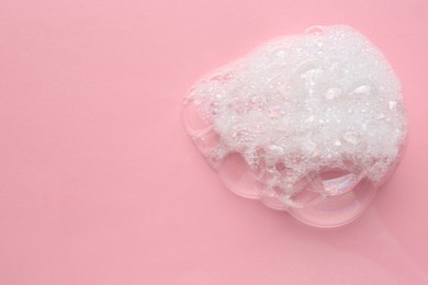 Drop of bath foam on pink background, top view. Space for text