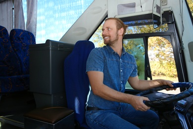 Photo of Professional bus driver at steering wheel. Passenger transportation