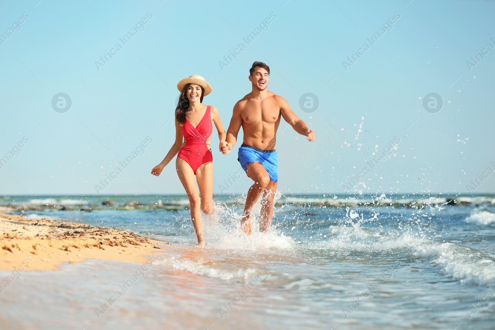 Photo of Happy young couple having fun at beach on sunny day