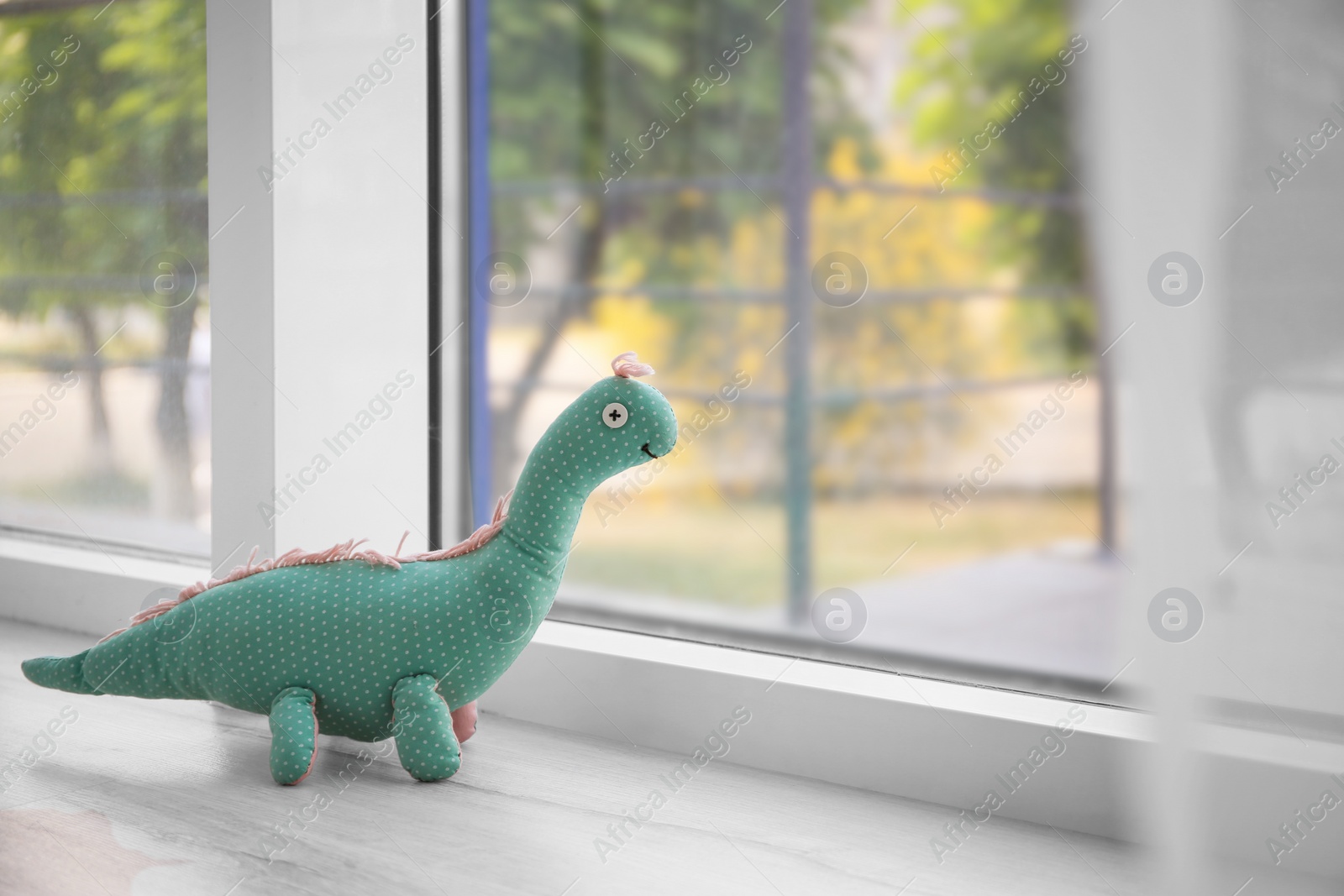 Photo of Abandoned toy dinosaur on window sill. Time to visit child psychologist