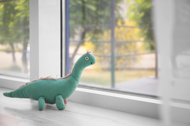 Abandoned toy dinosaur on window sill. Time to visit child psychologist