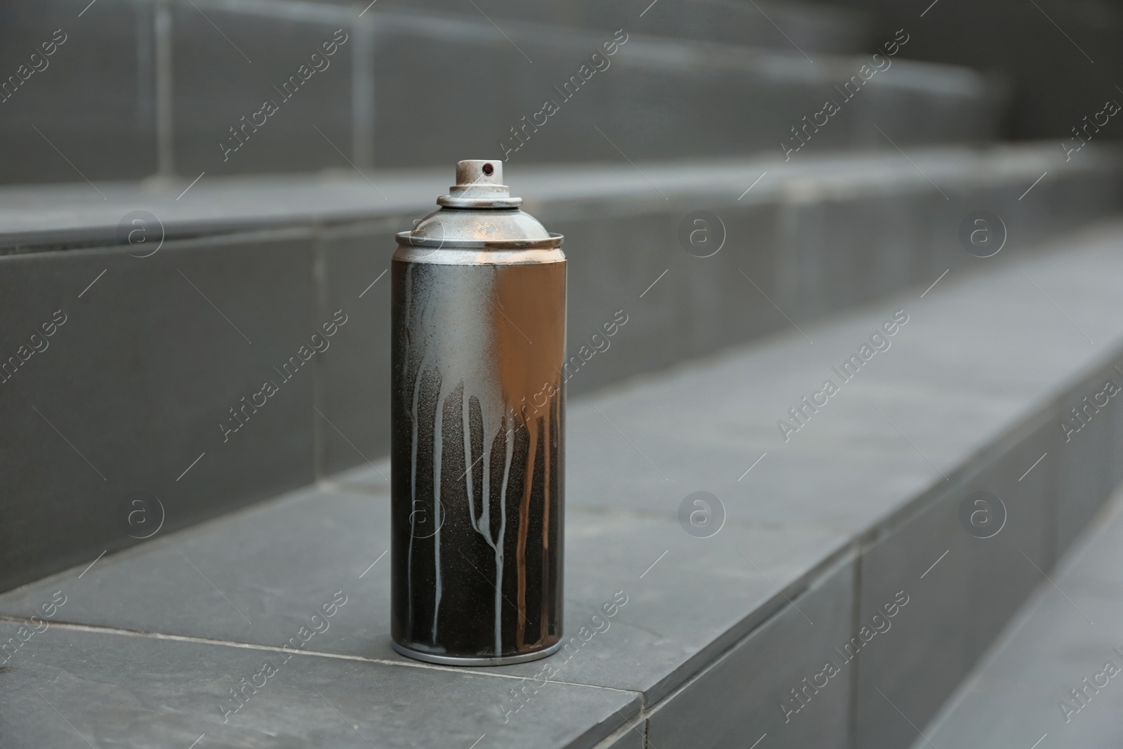 Photo of Used can of spray paint on stairs. Space for text