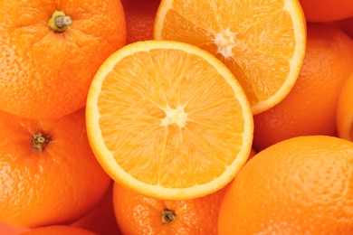 Cut and whole fresh ripe oranges as background, top view