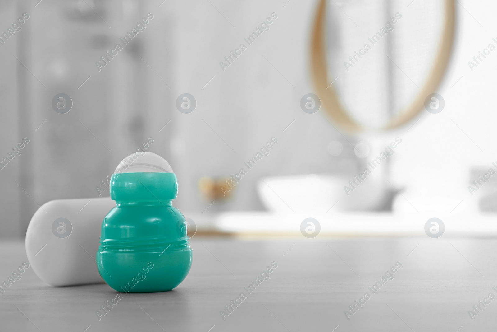 Photo of Deodorant container on table in bathroom. Space for text