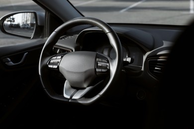 Photo of Black steering wheel inside of modern car