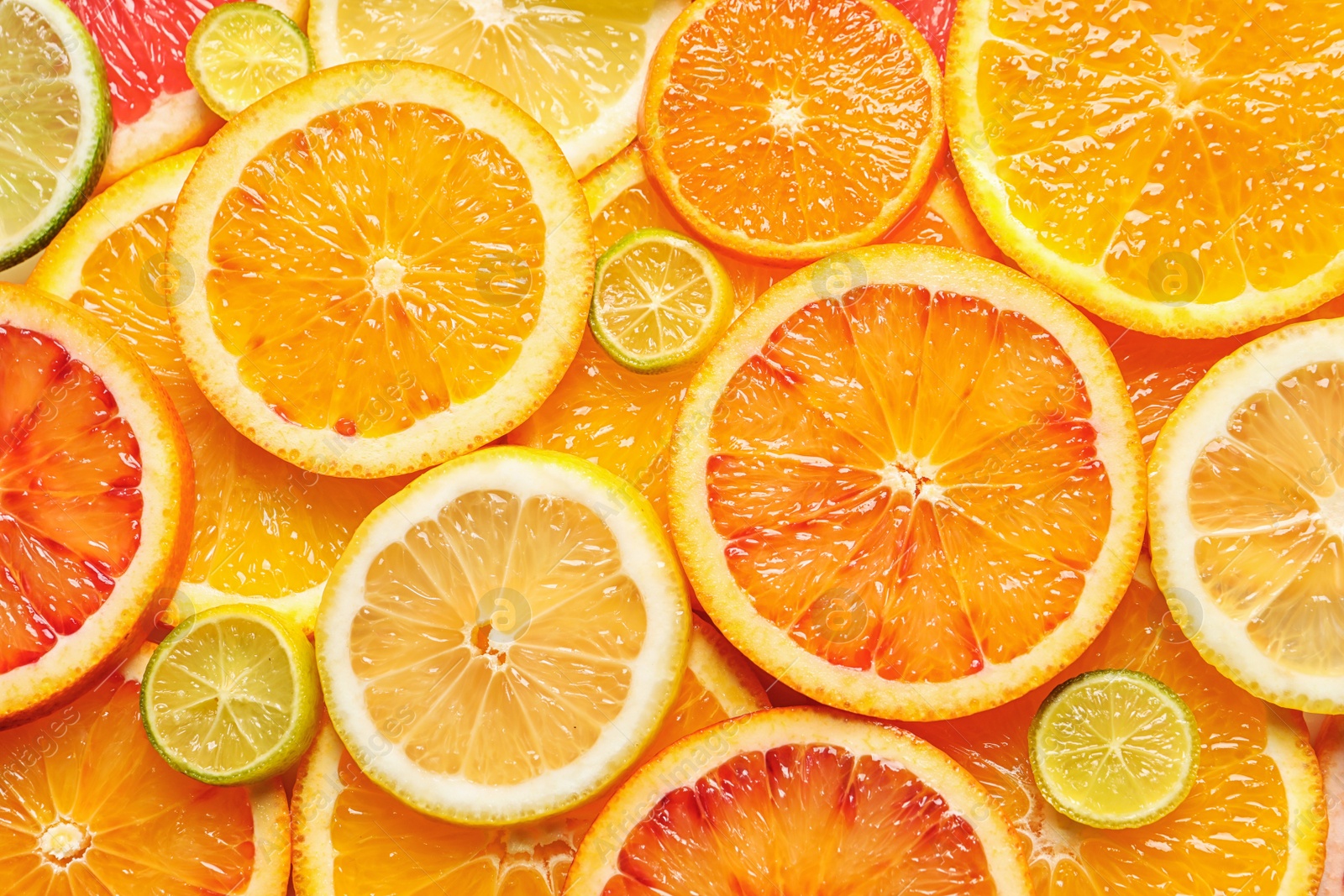 Photo of Slices of fresh citrus fruits as background, top view